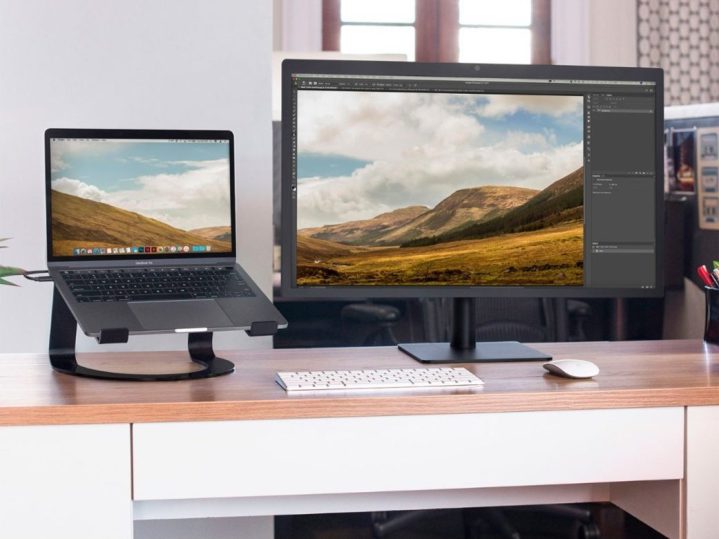 The Twelve South Curve Stand holds a laptop next to a large monitor at home.