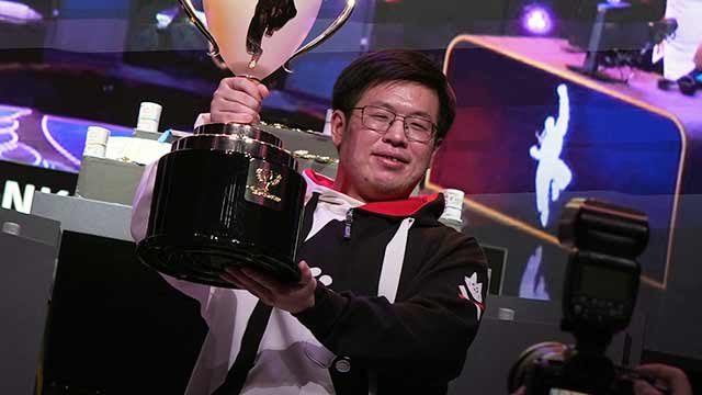 Uma holding the Capcom Cup X trophie.