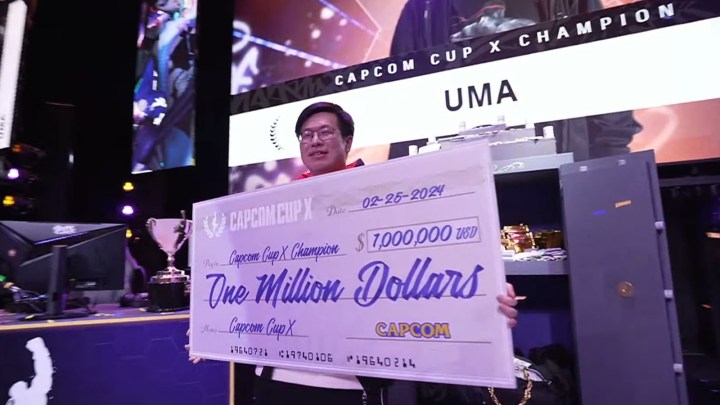 A player holds a check for a million dollars at a Street Fighter 6 tournament.
