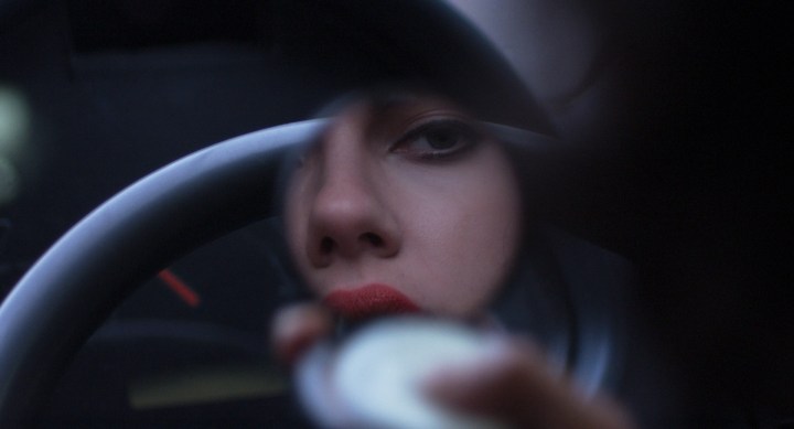 Una mujer se mira en un espejo compacto en Under the Skin.