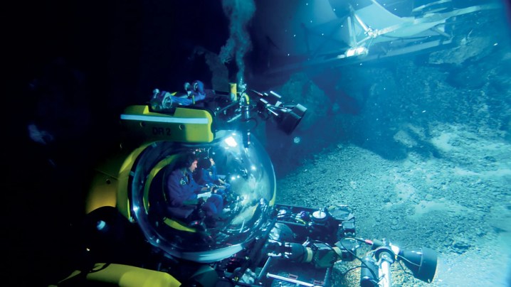 Homens em navios viajam debaixo d'água em Aliens of the Deep.