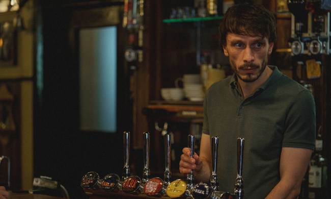 A man standing behind a bar, glancing to his side in a scene from Baby Reindeer on Netflix.