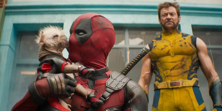 A dog licks Deadpool as Logan looks on in Deadpool & Wolverine.
