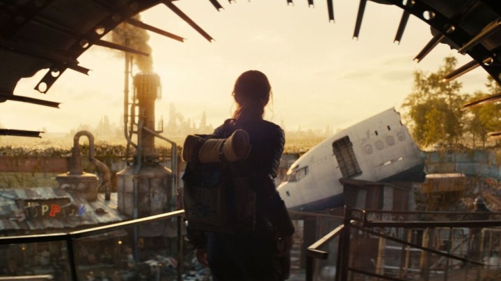 A woman looks out at an industrial landscape in Fallout.