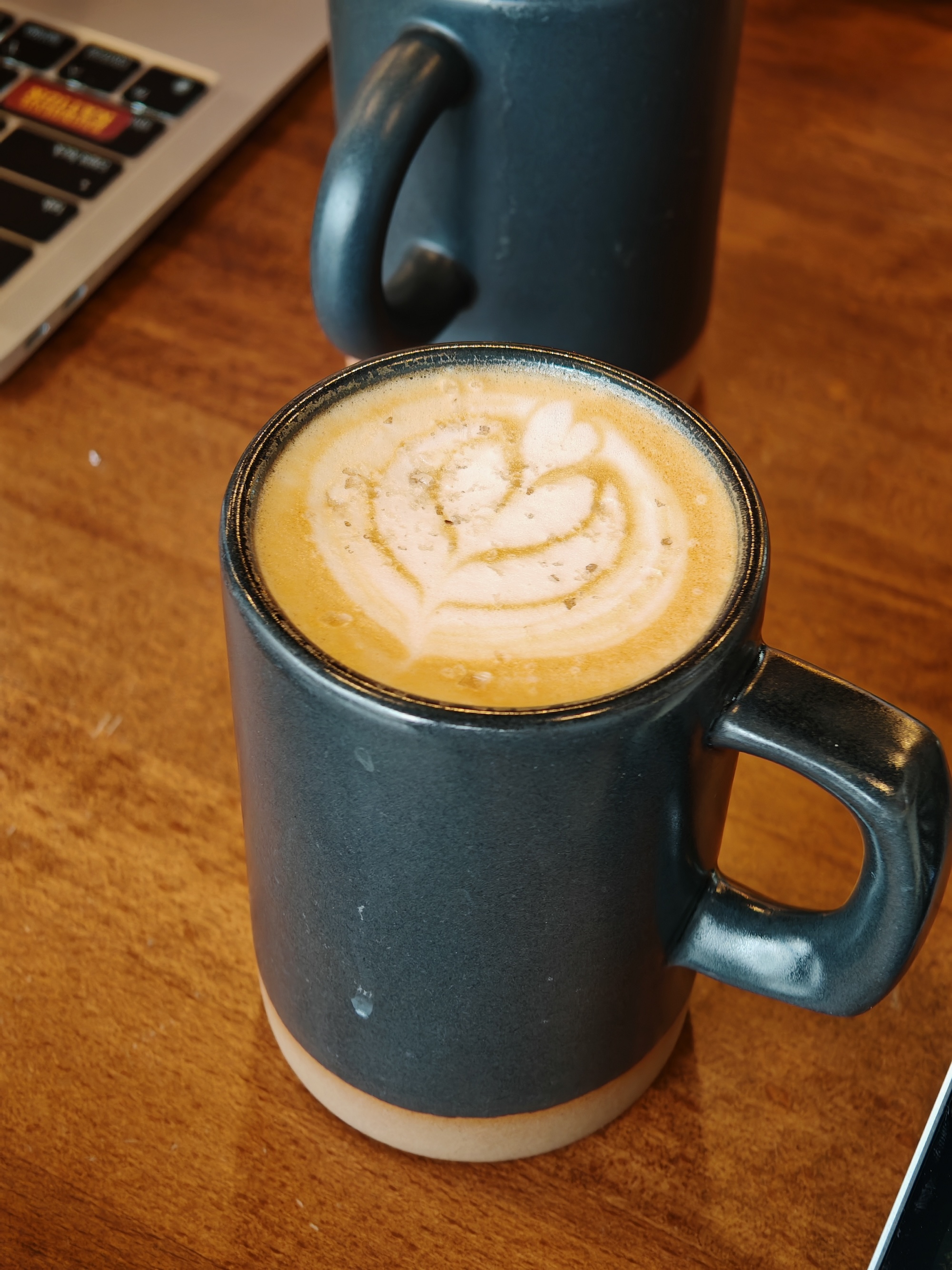 Una foto de una taza de café con un corazón dibujado en la parte superior, tomada con el Honor Magic 6 RSR.