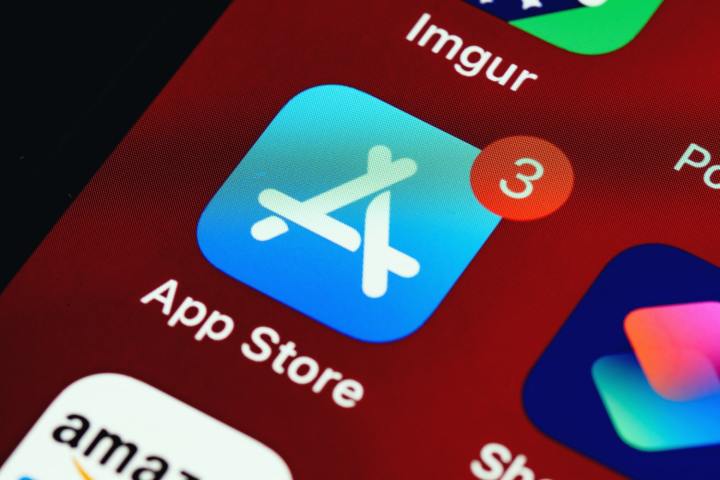 نمای نزدیک صفحه اصلی iOS که نماد فروشگاه App را با سه اعلان نشان می دهد.