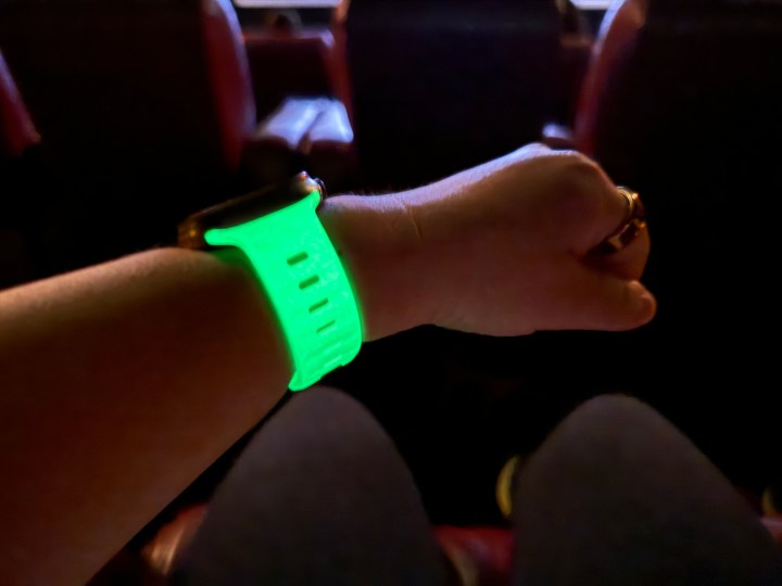 Nomad Glow 2.0 运动表带在黑暗的电影院中闪闪发光。