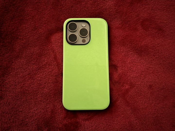 Nomad Glow 2.0 Sport Case on an iPhone 15 Pro in a dark room.