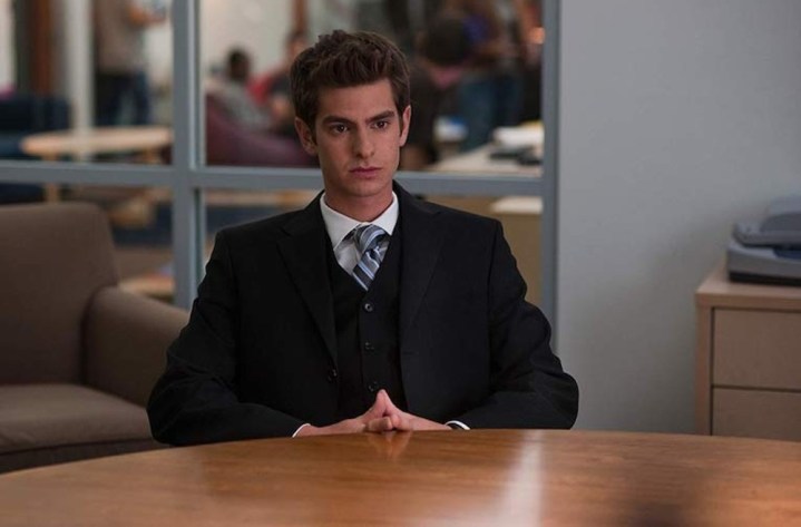 Andrew Garfield sits at a table in The Social Network.