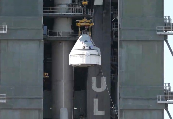 बोइंग के स्टारलाइनर अंतरिक्ष यान को एटलस वी रॉकेट पर रखा जा रहा है।