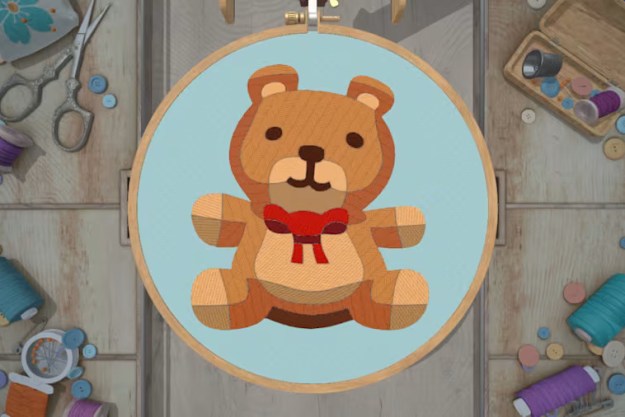 A teddy beat sits on an embroidery hoop in Stitch.