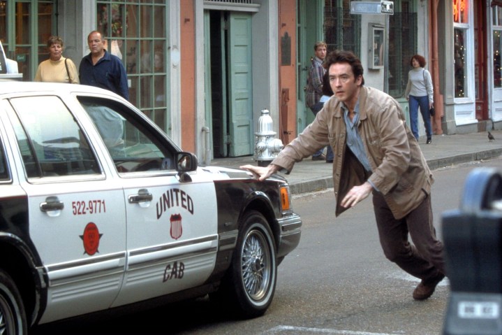 A man stops a police car in The Runaway Jury.