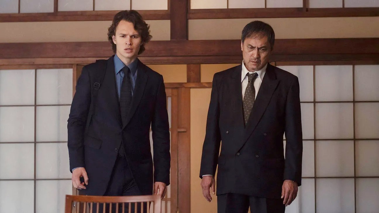 टोक्यो वाइस में एक घर में दो आदमी खड़े हैं।