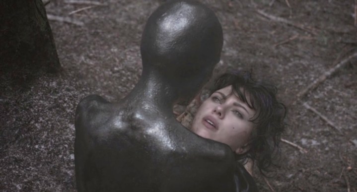 An alien looks down at a human face in Under the Skin.