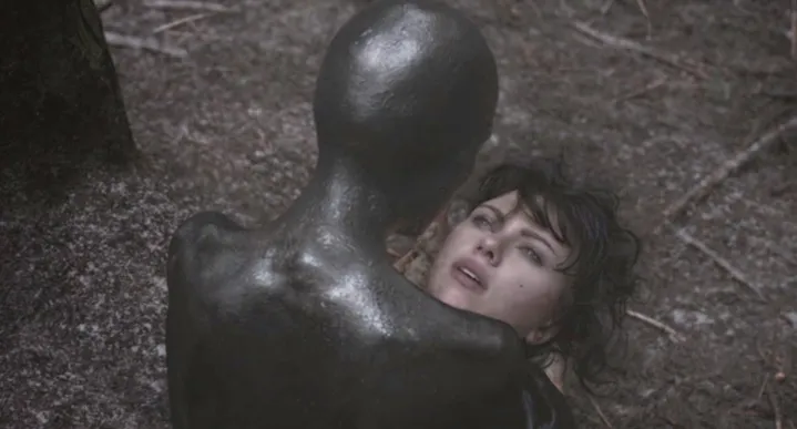 An alien looks down at a human face in Under the Skin.