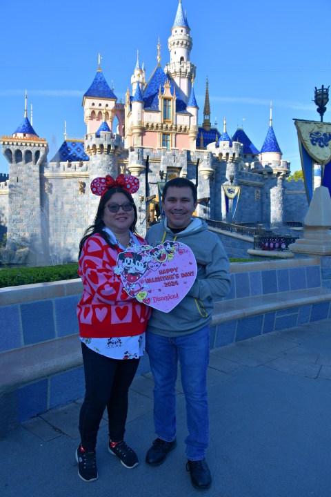 Pareja frente al castillo en Disneyland el día de San Valentín.