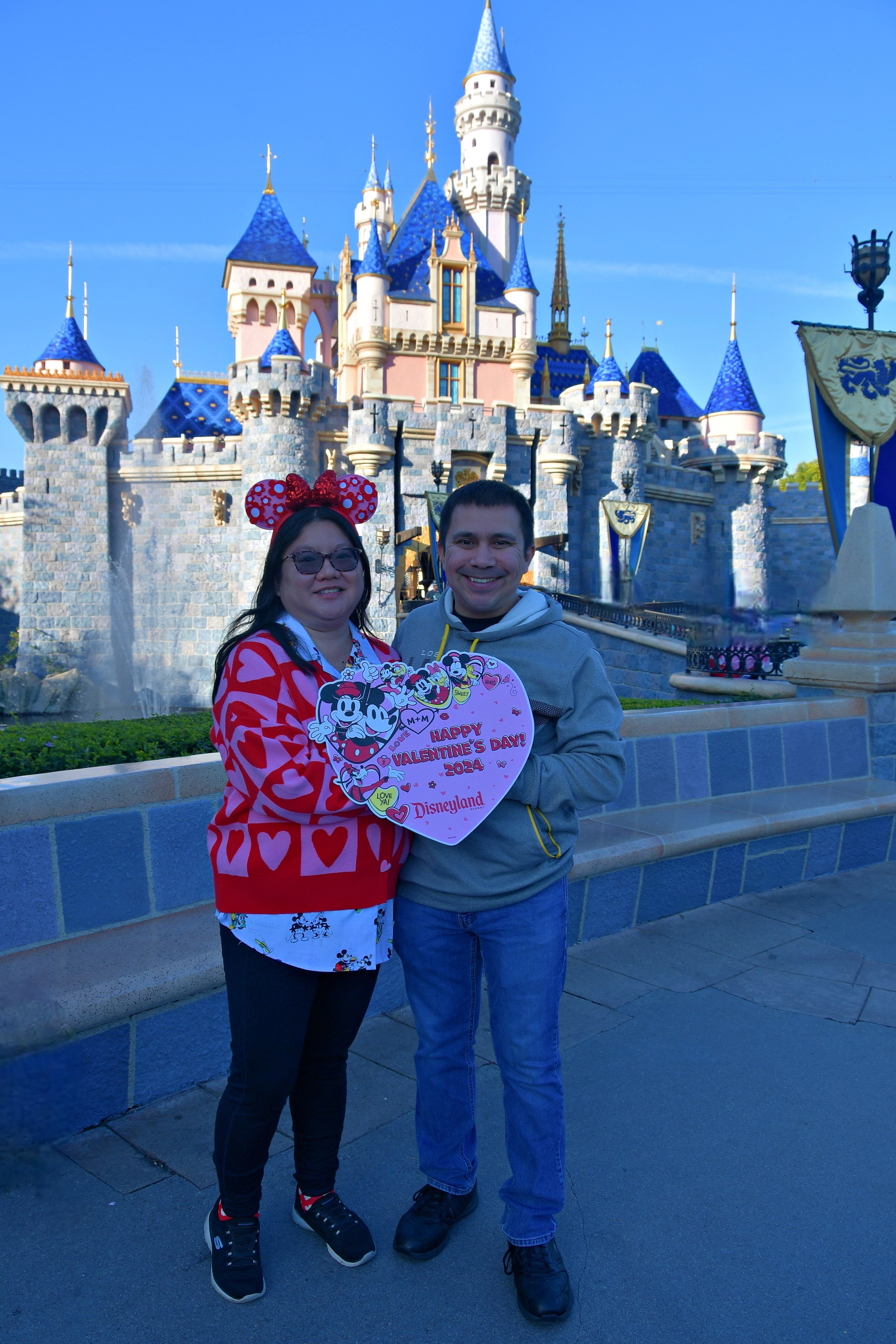 Pareja frente al castillo en Disneyland el día de San Valentín.