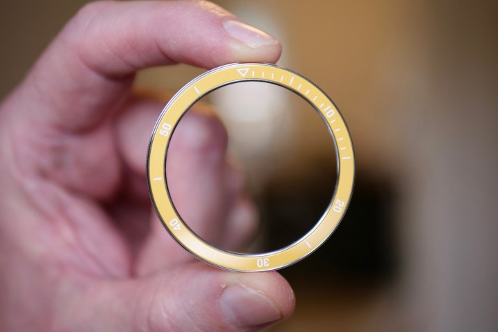 A person holding a yellow bezel for the Xiaomi Watch S3.