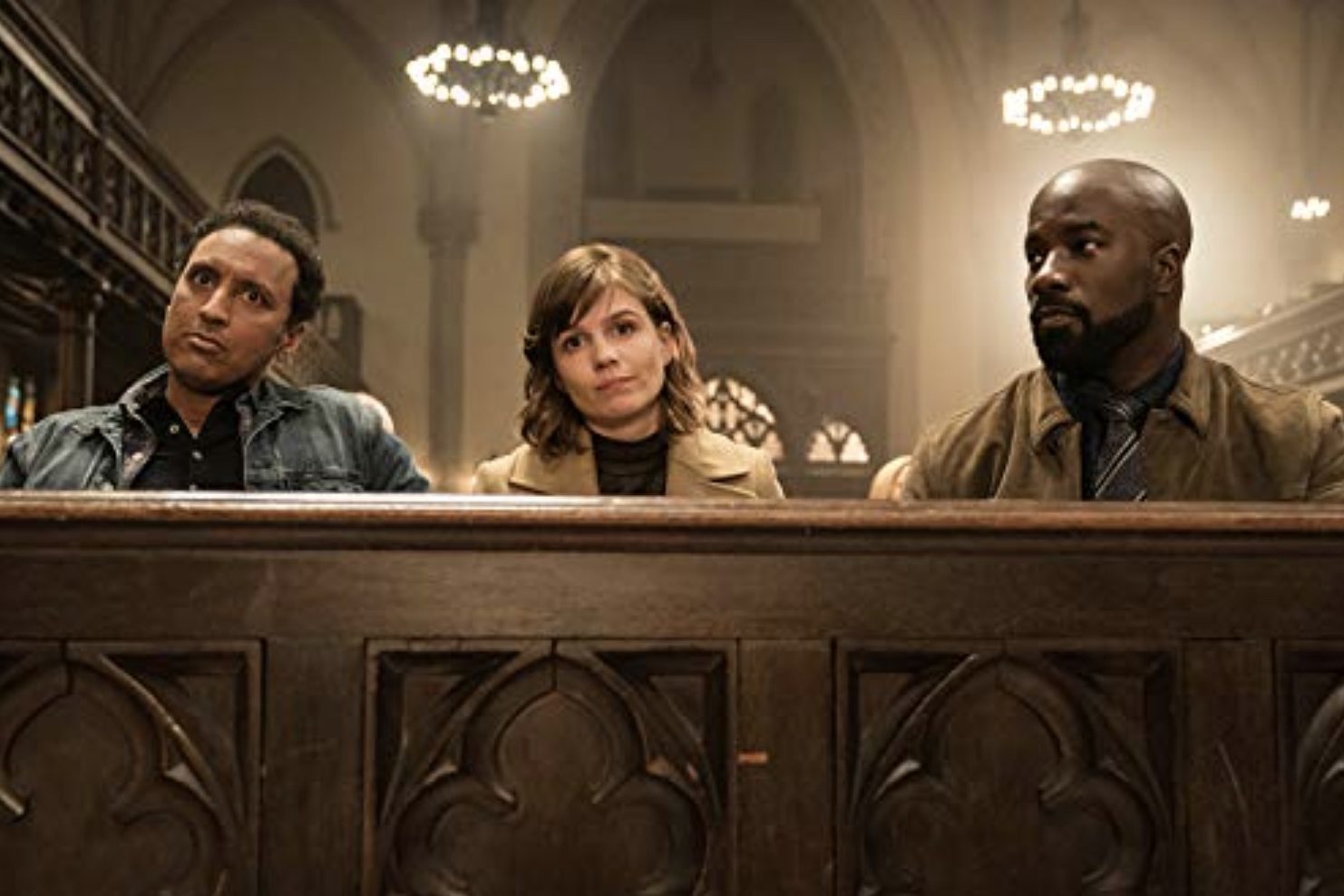 Two men and a woman sit in a Church pew.