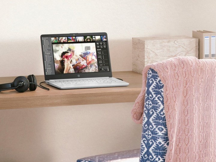 14-дюймовый ноутбук HP на небольшом столе с наушниками.