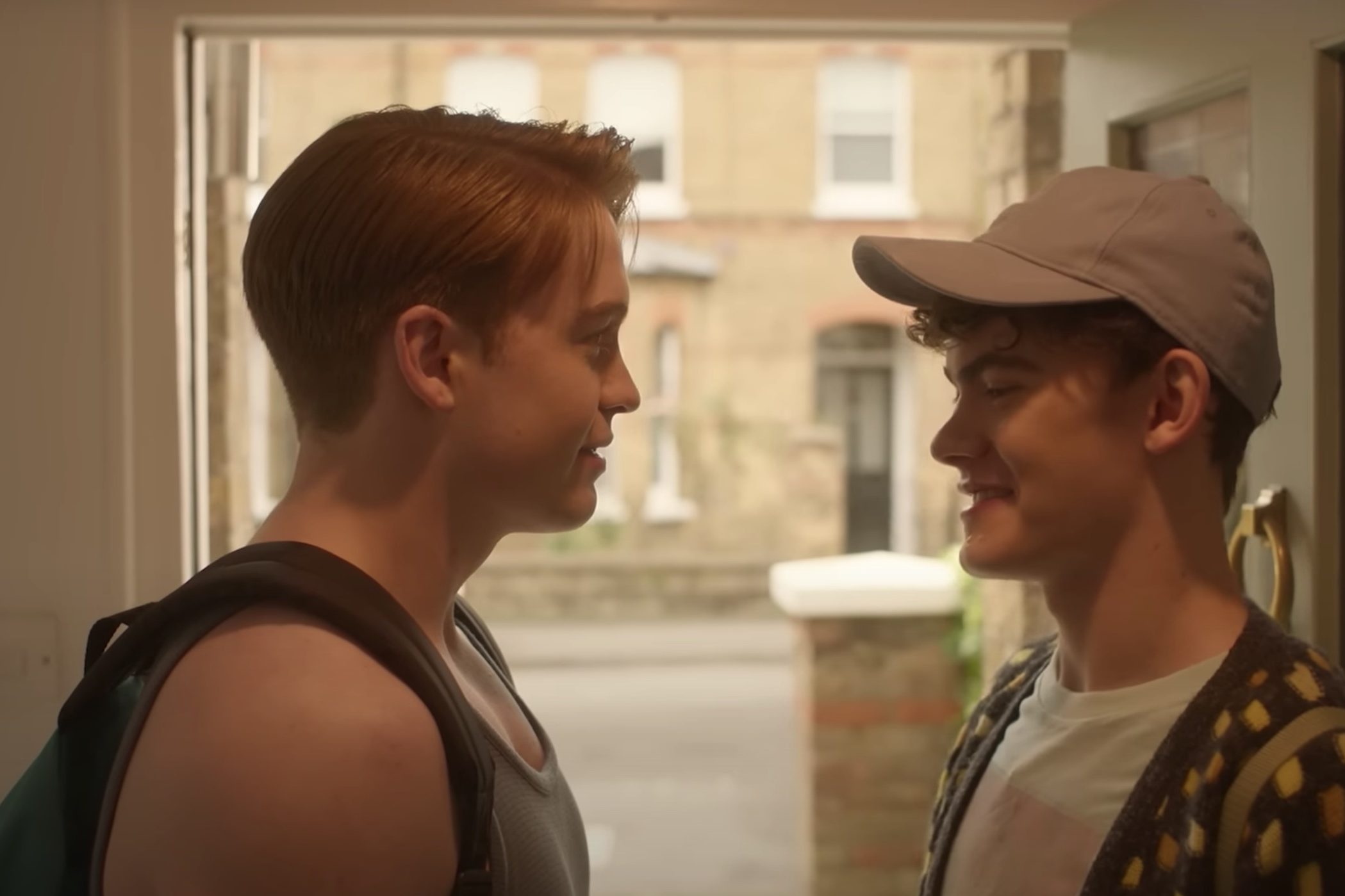 Two boys stare at each other in the front of a house.