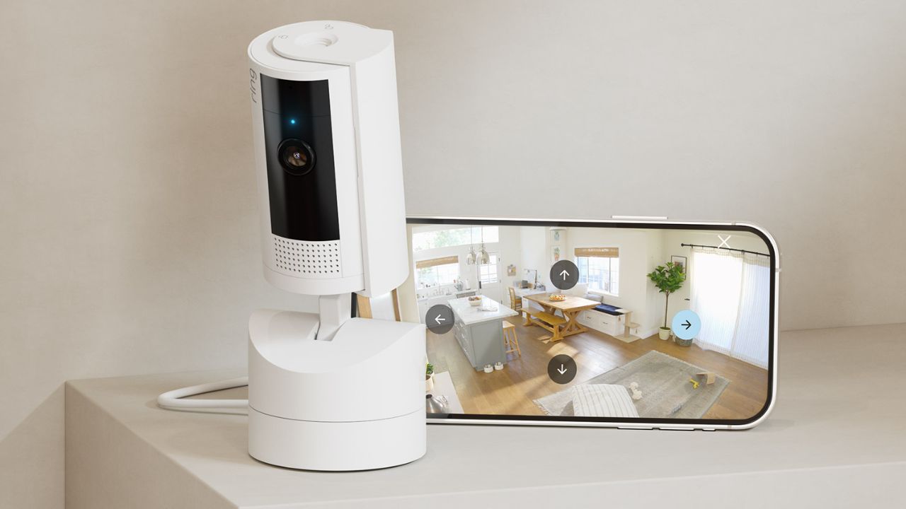 The Ring Pan-Tilt Indoor Cam next to a smartphone.
