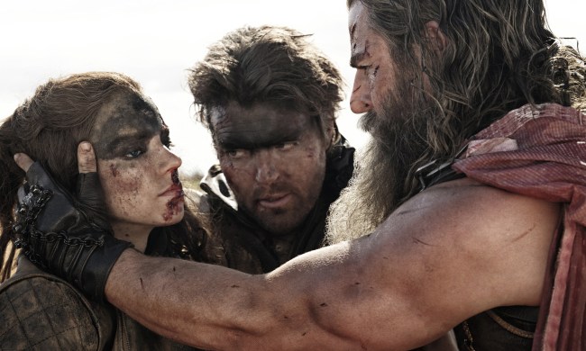 Tom Burke stands between Anya Taylor-Joy and Chris Hemsworth in Furiosa: A Mad Max Saga.