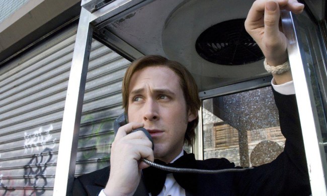 A low-angle shot of Ryan Gosling in a phone booth holding the receiver in a scene from All Good Things.