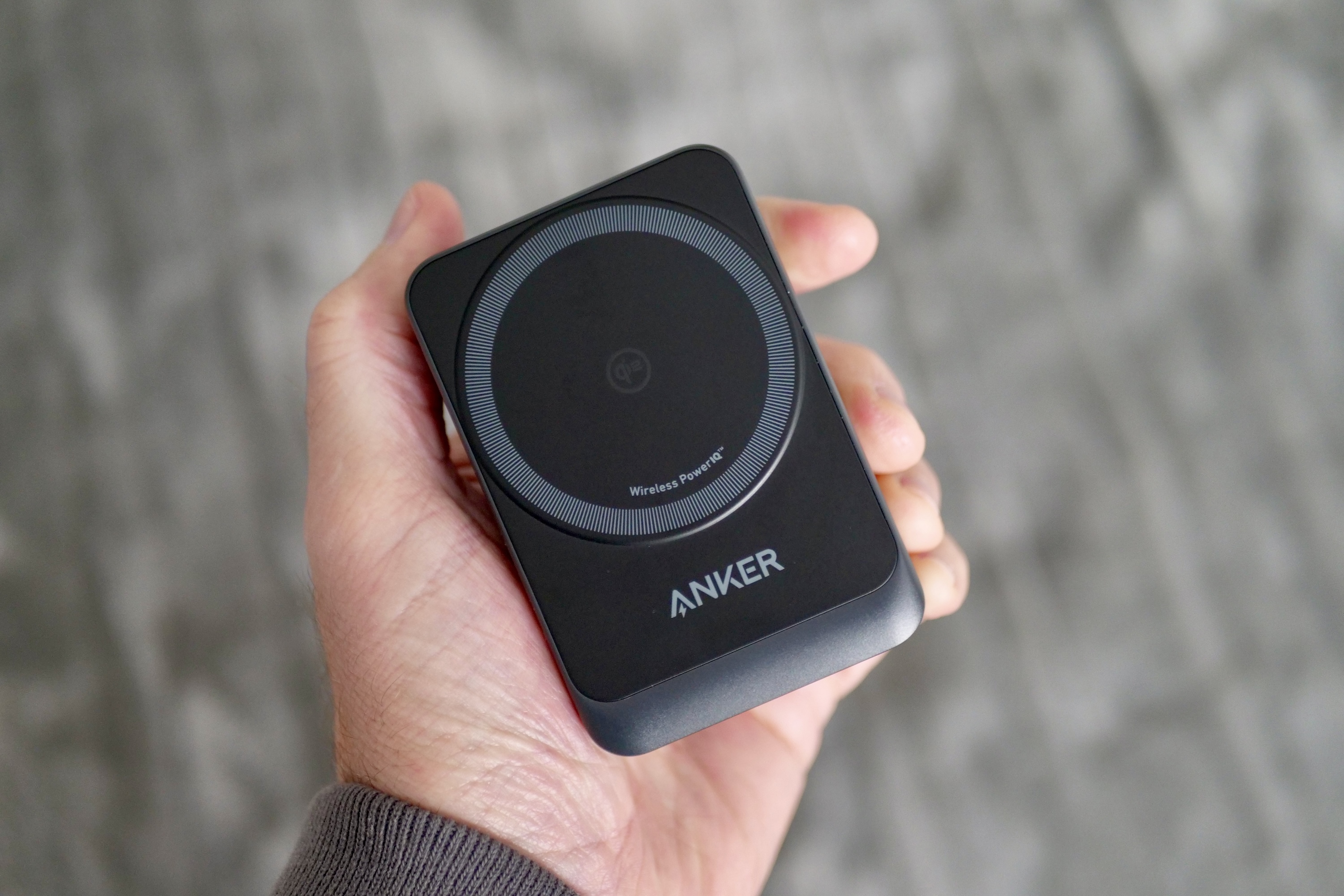 A person holding the folded up Anker MagGo Wireless Charging Station.