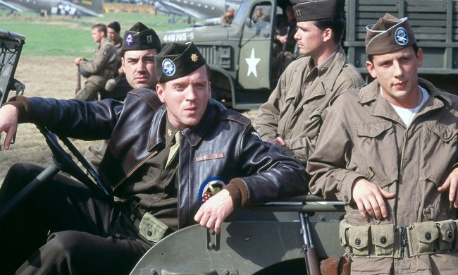 Four men in a vehicle wearing army uniforms from World War II in a scene from Band of Brothers.
