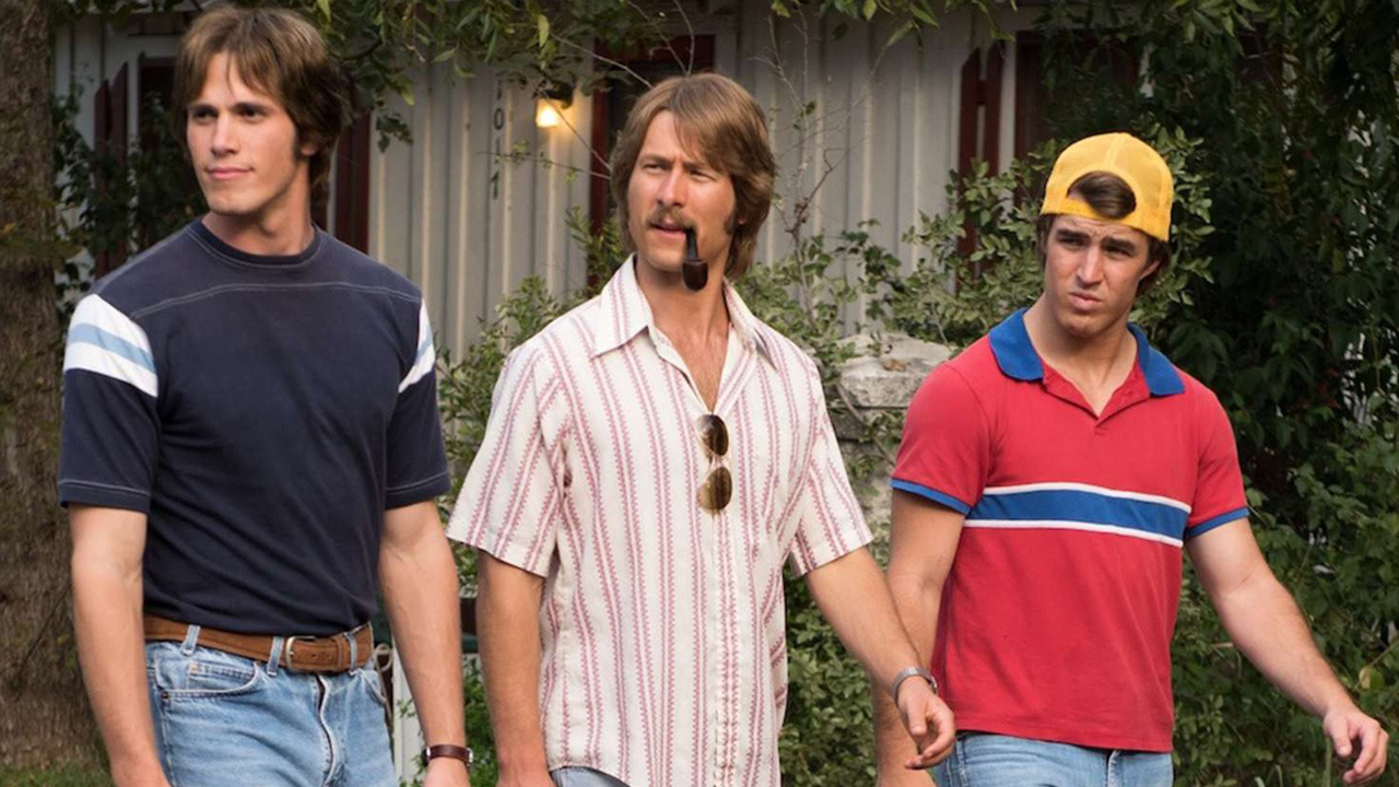 Three men dressed casually with '80s haircuts walking down the street in a scene from Everybody Wants Some!!