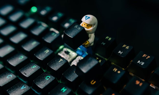 A broken keyboard with a lego man on it.