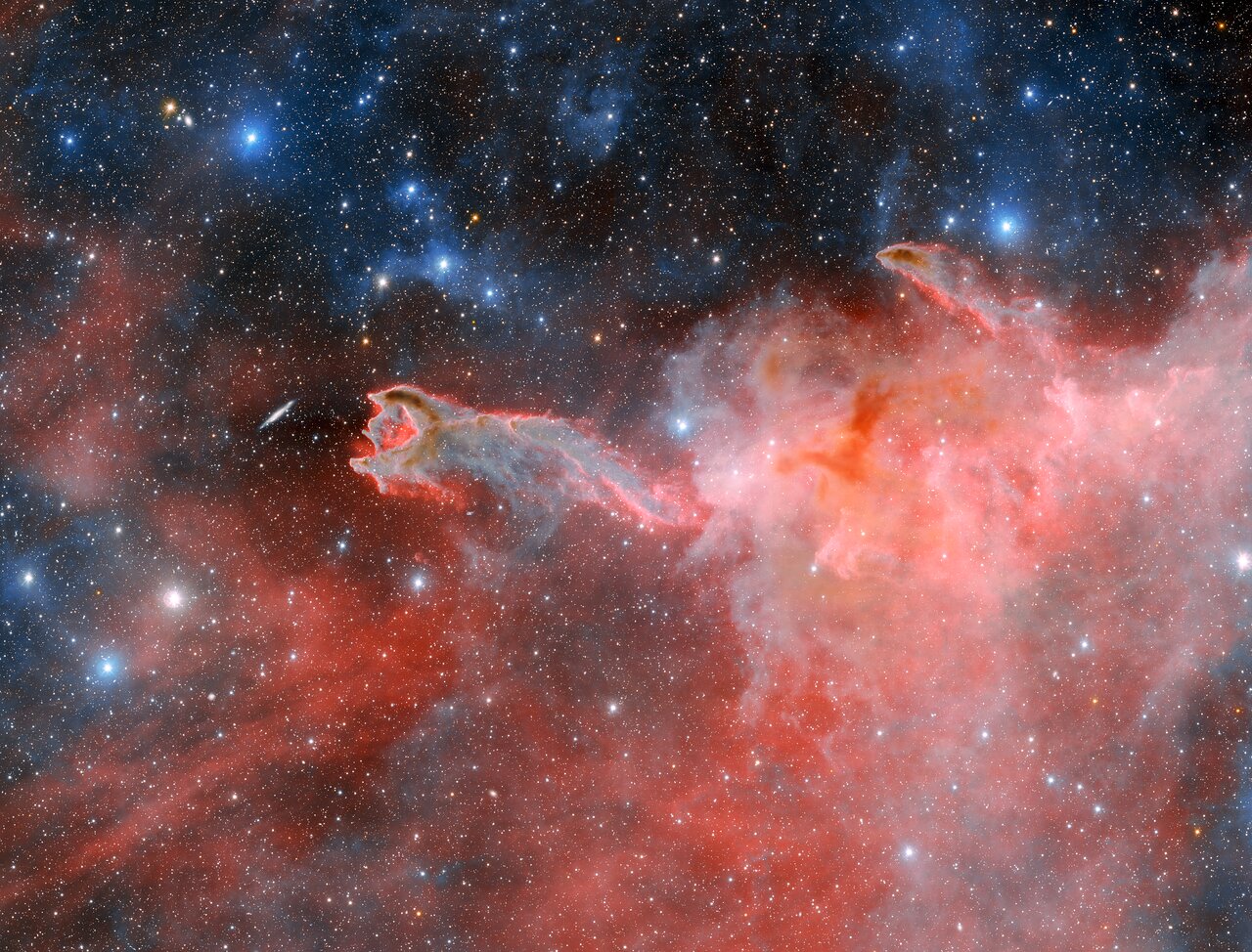 This cloudy, ominous structure is CG 4, a cometary globule nicknamed ‘God’s Hand’. CG 4 is one of many cometary globules present within the Milky Way, and how these objects get their distinct form is still a matter of debate among astronomers. This image was captured by the Department of Energy-fabricated Dark Energy Camera on the U.S. National Science Foundation Víctor M. Blanco 4-meter Telescope at Cerro Tololo Inter-American Observatory, a Program of NSF NOIRLab. In it, the features that classify CG 4 as a cometary globule are hard to miss. Its dusty head and long, faint tail vaguely resemble the appearance of a comet, though they have nothing in common. Astronomers theorize that cometary globules get their structure from the stellar winds of nearby hot, massive stars.
