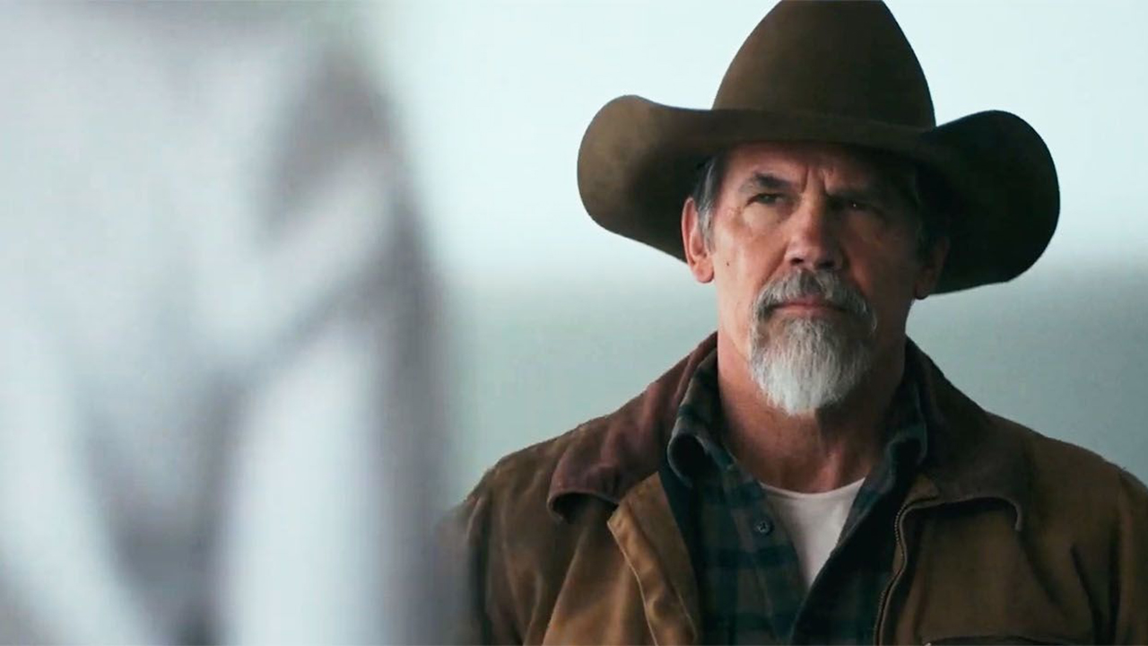Josh Brolin wearing a cowboy hat and looking at someone in a scene from Outer Range.