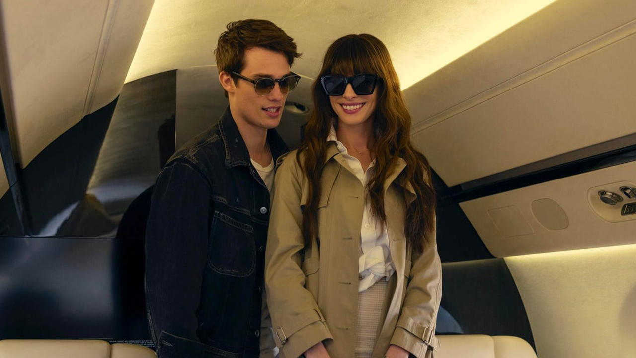 A young man and woman on a plane, both smiling and wearing sunglasses in a scene from The Idea of You on Amazon Prime Video.